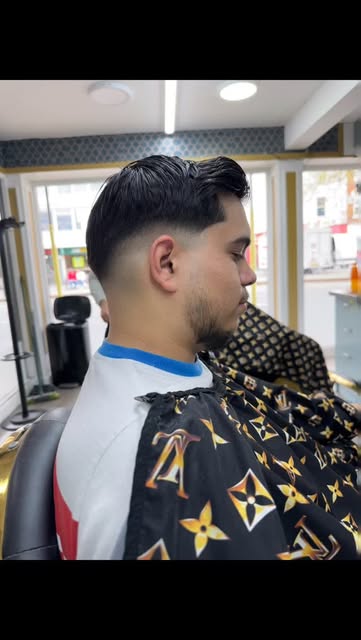 Styled dark hair with a close fade and neatly shaped beard